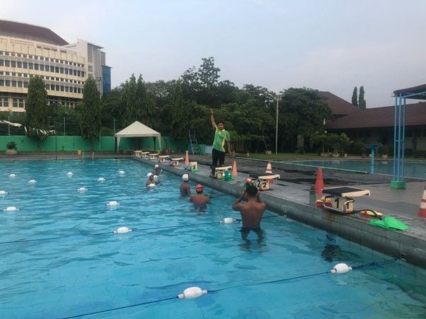 Pelatih renang SLOMPN Unesa memberikan instruksi kepada para atlet saat sesi latihan di kolam renang internasional Unesa Kampus Lidah Wetan. Foto: Dokumen Slompn Unesa 