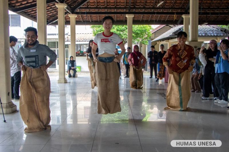 Mahasiswa asing mencoba permainan tradisional, balap karung disaksikan mahasiswa BIPA UNESA lainnya. 